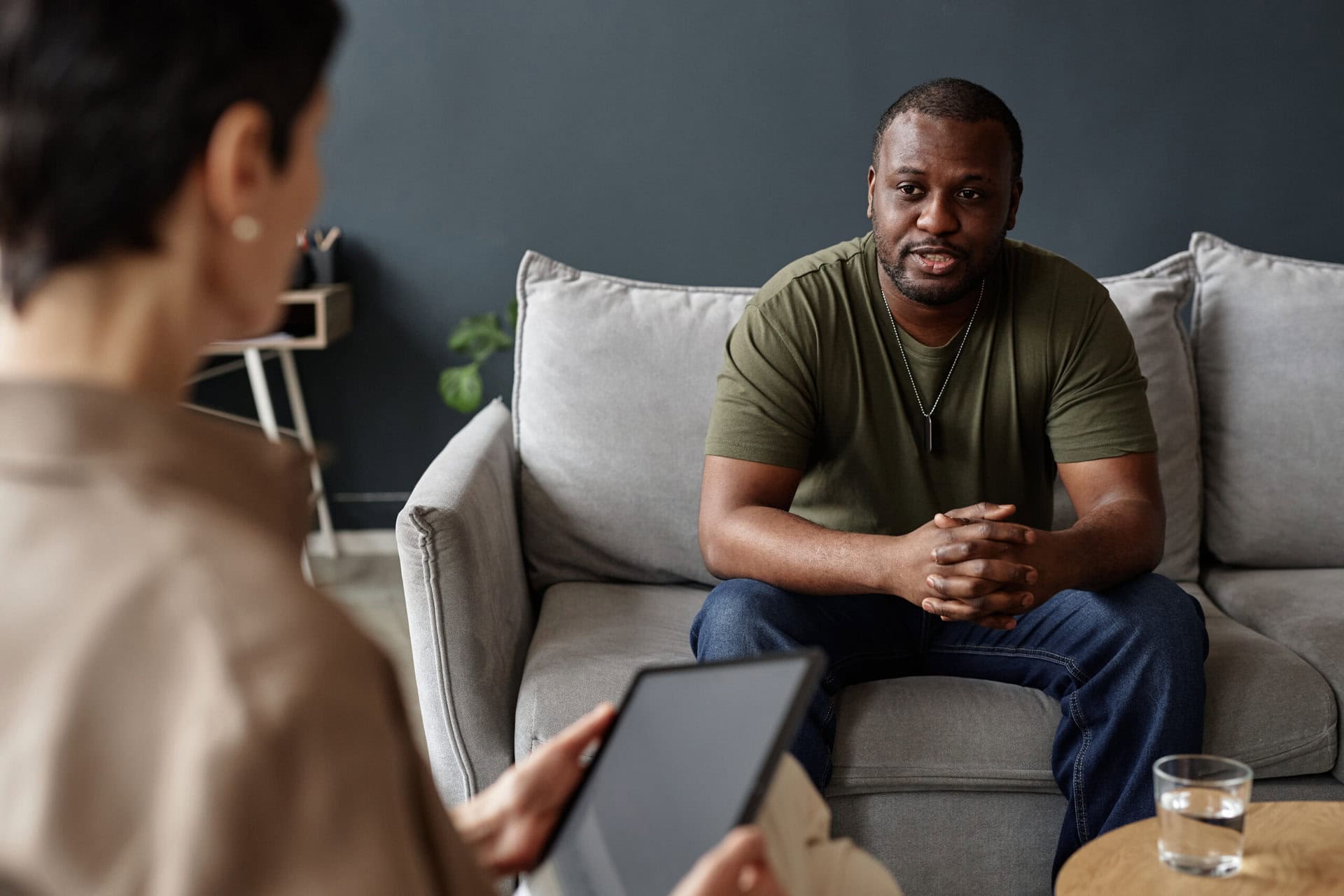 Portrait of African American adult man as army veteran sharing struggles with mental health therapist in session