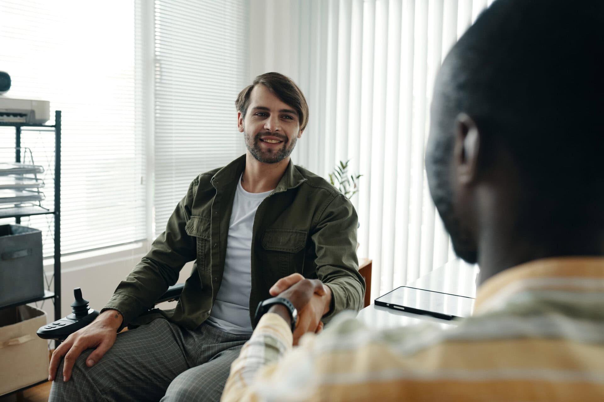 Businessman with disability greeting his colleague at meeting