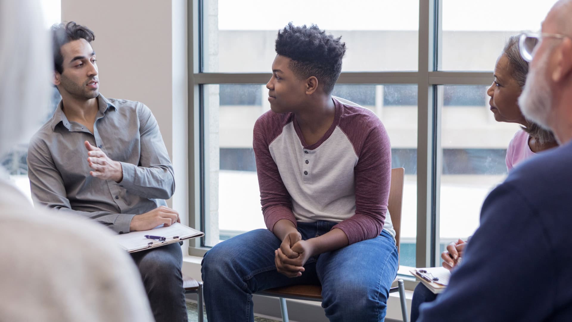 A group of individuals participating in a supportive group counseling session for addiction and mental health treatment in Arvada, CO.
