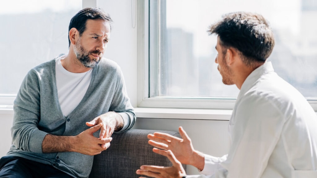 Professional counseling session for addiction and mental health treatment in Lakewood, CO, showing a supportive therapist and client in a comfortable office setting.